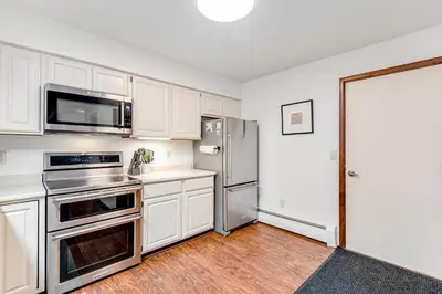a kitchen with white cabinets and a stainless steel refrigerator at Meadow Lodge - Dog Friendly! in Frisco