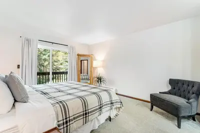 a bedroom with a bed and a chair and a window at Meadow Lodge - Dog Friendly! in Frisco