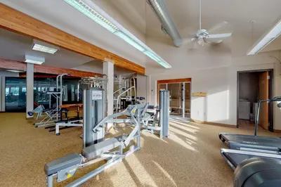 a gym with treadmills and cardio equipment in a building at Fraser Family Getaway in Fraser