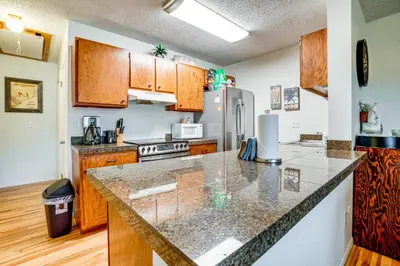 a kitchen with wooden cabinets and a granite counter top at Walk to Main St Recently Renovated Frisco Condo in Frisco