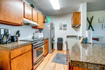 a kitchen with wooden cabinets and a stainless steel refrigerator at Walk to Main St Recently Renovated Frisco Condo in Frisco
