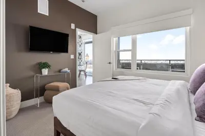 a bedroom with a large bed and a large window at Top Floor - Amazing Windows - Zuni Lofts in Denver