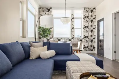 a living room with a blue couch and a table at Top Floor - Amazing Windows - Zuni Lofts in Denver