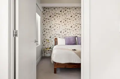 a bedroom with a bed with purple pillows at Top Floor - Amazing Windows - Zuni Lofts in Denver