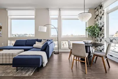 a living room with a blue couch and a table at Top Floor - Amazing Windows - Zuni Lofts in Denver