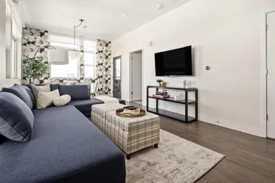 a living room with a blue couch and a tv at Top Floor - Amazing Windows - Zuni Lofts in Denver