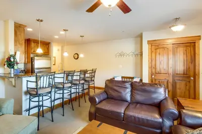 a living room with a couch and a bar with stools at Central Fraser Condo 8 Mi to Winter Park Ski! in Fraser
