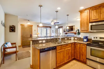 a kitchen with wooden cabinets and stainless steel appliances at Central Fraser Condo 8 Mi to Winter Park Ski! in Fraser