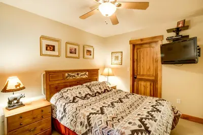 a bedroom with a bed and a flat screen tv at Central Fraser Condo 8 Mi to Winter Park Ski! in Fraser