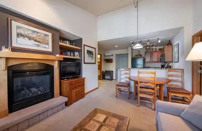 a living room with a fireplace and a dining room at Zephyr Mountain Lodge Select-Rated 1602 in Winter Park