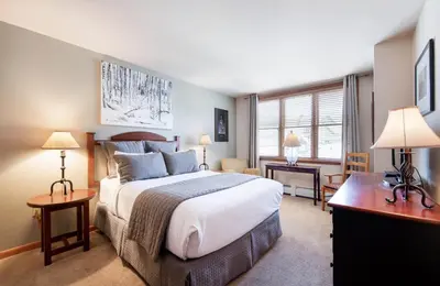 a bedroom with a large bed and a desk at Zephyr Mountain Lodge Select-Rated 1602 in Winter Park