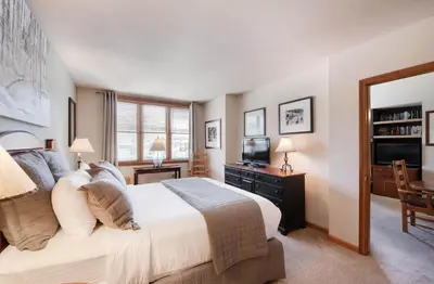 a bedroom with a large bed and a television at Zephyr Mountain Lodge Select-Rated 1602 in Winter Park
