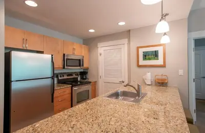 a kitchen with a stainless steel refrigerator and a sink at Excellent townhome style condo - Close to the Gondola - Fraser Crossing Founder Pointe condo in Winter Park