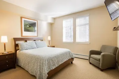 a bedroom with a bed and a chair at Simple and Comfortable Fraser Crossing Founders Pointe Condo Facing Ski Resort condo in Winter Park