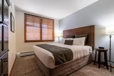 a bedroom with a large bed and a window at Perfectly Cozy 3rd floor Zephyr Mountain Lodge Condo with remodeled bath condo in Winter Park