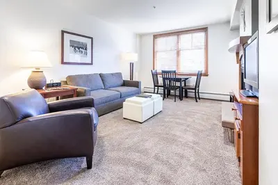 a living room with a couch and a table at Perfectly Cozy 3rd floor Zephyr Mountain Lodge Condo with remodeled bath condo in Winter Park