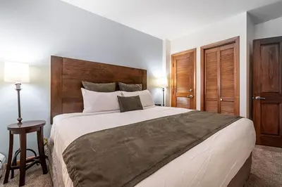 a bedroom with a large bed with a wooden headboard at Perfectly Cozy 3rd floor Zephyr Mountain Lodge Condo with remodeled bath condo in Winter Park