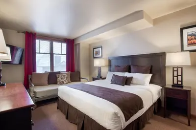 a bedroom with a large bed and a couch at Ski-In Ski-Out Cozy 4th Floor Zephyr Mountain Lodge Condo Tucked Into The Woods condo in Winter Park