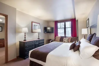 a bedroom with a large bed and a window at Ski-In Ski-Out Cozy 4th Floor Zephyr Mountain Lodge Condo Tucked Into The Woods condo in Winter Park