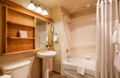 a bathroom with a sink and a toilet and a tub at Ski-In Ski-Out Cozy 4th Floor Zephyr Mountain Lodge Condo Tucked Into The Woods condo in Winter Park