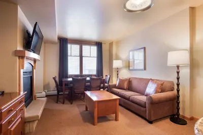 a living room with a couch and a table at Ski-In Ski-Out Cozy 4th Floor Zephyr Mountain Lodge Condo Tucked Into The Woods condo in Winter Park