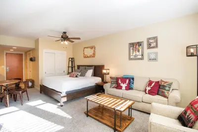 a bedroom with a bed and a couch at Beautiful Ski-In Ski-Out Top Floor Studio Condo at Fraser Crossing Founders Pointe condo in Winter Park
