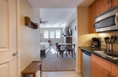 a kitchen with a table and a dining room at Beautiful Ski-In Ski-Out Top Floor Studio Condo at Fraser Crossing Founders Pointe condo in Winter Park