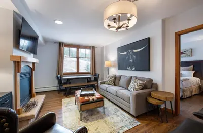 a living room with a couch and a tv at Wonderful Zephyr Mountain Lodge condo with forest views - close to gondola condo in Winter Park