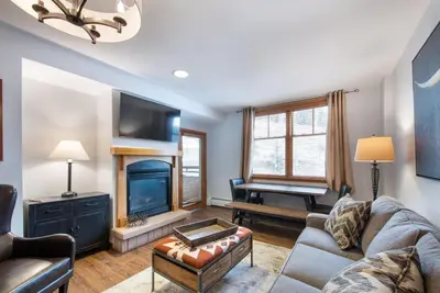 a living room with a couch and a piano at Wonderful Zephyr Mountain Lodge condo with forest views - close to gondola condo in Winter Park