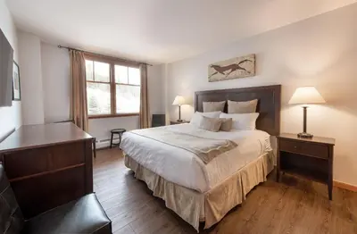a bedroom with a bed and a desk and a window at Wonderful Zephyr Mountain Lodge condo with forest views - close to gondola condo in Winter Park
