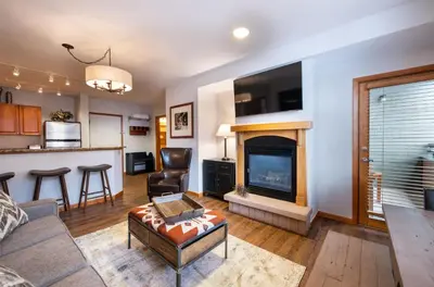 a living room with a couch and a fireplace at Wonderful Zephyr Mountain Lodge condo with forest views - close to gondola condo in Winter Park
