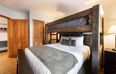 a bedroom with a large bed with a wooden headboard at Wonderful Zephyr Mountain Lodge condo with forest views - close to gondola condo in Winter Park