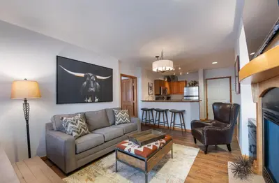a living room with a couch and a table at Wonderful Zephyr Mountain Lodge condo with forest views - close to gondola condo in Winter Park