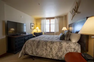 a bedroom with a bed and a flat screen tv at Ski Slope View Remodeled Zephyr Mountain Lodge Condo condo in Winter Park