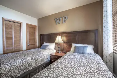 a hotel room with two beds and a sign on the wall at Ski Slope View Remodeled Zephyr Mountain Lodge Condo condo in Winter Park