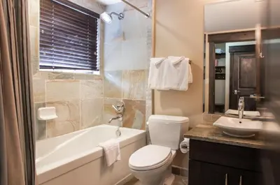 a bathroom with a tub and a toilet and a sink at Spacious Village View Townhouse with Fireplace at Parry Peak Lofts townhouse in Winter Park