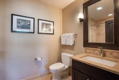 a bathroom with a toilet and a sink and a mirror at Spacious Village View Townhouse with Fireplace at Parry Peak Lofts townhouse in Winter Park