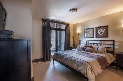 a bedroom with a bed and a large window at Spacious Village View Townhouse with Fireplace at Parry Peak Lofts townhouse in Winter Park