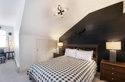 a bedroom with a bed with a black and white checkered blanket at Spacious Fraser Crossing Founders Pointe Condo with Balcony and Village Views condo in Winter Park