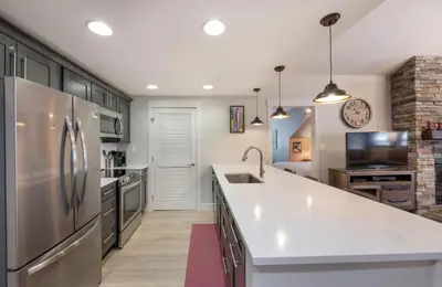 a kitchen with a stainless steel refrigerator and a sink at Spacious Fraser Crossing Founders Pointe Condo with Balcony and Village Views condo in Winter Park