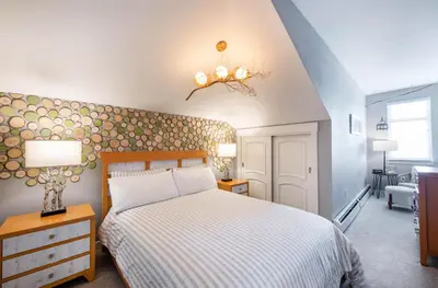 a bedroom with a bed with a white comforter at Spacious Fraser Crossing Founders Pointe Condo with Balcony and Village Views condo in Winter Park