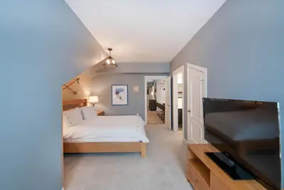 a bedroom with a bed and a flat screen tv at Spacious Fraser Crossing Founders Pointe Condo with Balcony and Village Views condo in Winter Park