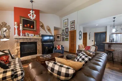 a living room with a couch and a fireplace at Top Floor Condo with Views of Ski Slopes and Gondola in Zephyr Mountain Lodge condo in Winter Park