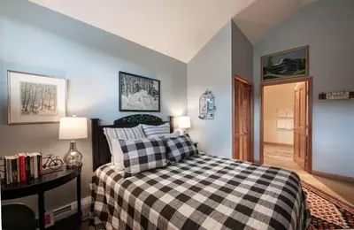 a bedroom with a black and white checkered bed at Top Floor Condo with Views of Ski Slopes and Gondola in Zephyr Mountain Lodge condo in Winter Park