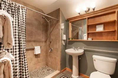 a bathroom with a shower and a toilet and a sink at Top Floor Condo with Views of Ski Slopes and Gondola in Zephyr Mountain Lodge condo in Winter Park