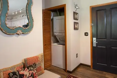 a living room with a couch and a mirror at Top Floor Condo with Views of Ski Slopes and Gondola in Zephyr Mountain Lodge condo in Winter Park