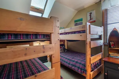 two bunk beds in a room with a desk at Top Floor Condo with Views of Ski Slopes and Gondola in Zephyr Mountain Lodge condo in Winter Park
