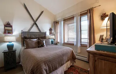 a bedroom with a bed and a sink and a window at Top Floor Condo with Views of Ski Slopes and Gondola in Zephyr Mountain Lodge condo in Winter Park