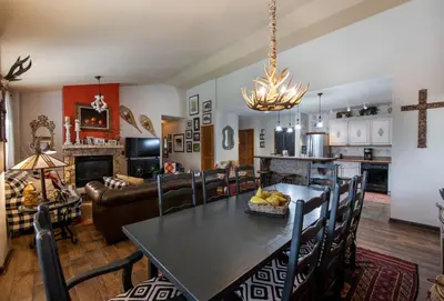 a kitchen and living room with a table and chairs at Top Floor Condo with Views of Ski Slopes and Gondola in Zephyr Mountain Lodge condo in Winter Park