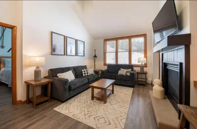a living room with a couch and a flat screen tv at Zephyr Mountain Lodge Premium-Rated 1705 in Winter Park